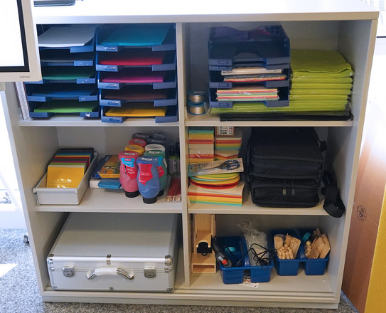 Schrank mit verschiedenem Bastel-Inhalt, z.B. Papier, Farben, Schere, Draht, etc.