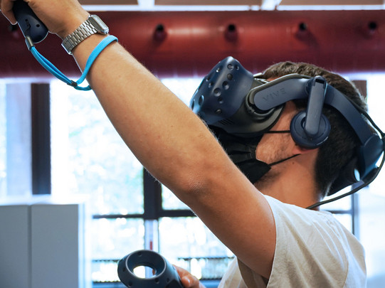 Student trägt eine Virtual-Reality-Brille und probiert diese aus