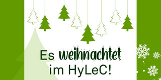 Grafik weißes Feld mit grünem Rand, verziert mit Schneeflocken und Weihnachtsbäumen, alles im TU-Grün. Text "Es weihnachtet im Hylec"