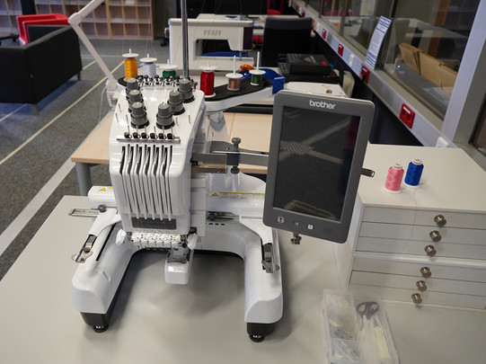 Stickmaschine auf Tisch im Raum