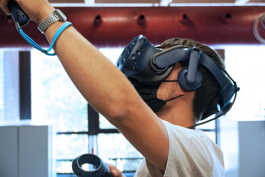 Student trägt virtual Reality Brille auf dem Kopf und probiert sie aus
