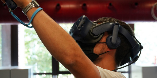 Student trägt eine Virtual-Reality-Brille und probiert diese aus