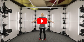 Startbild eines Videos. Abgebildet ein Mitarbeiter, der im Personenscanner mit ausgebreiteten Armen steht ,um abfotografiert zu werden.